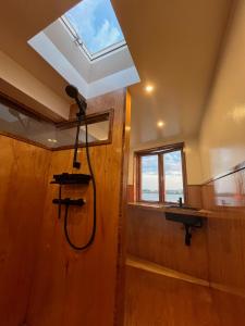 a bathroom with a shower with a window and a shower at Casey's Lake View House Boat in Amsterdam