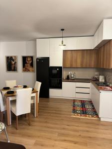 a kitchen with white cabinets and a table and chairs at Luli apartment Durrës in Durrës