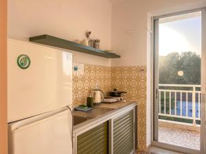 een keuken met een koelkast en een raam bij Prado Hotel Apartments in Limín Litochórou