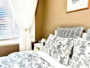 um quarto com uma cama com almofadas e uma janela em Langley 半地下室独立出入温馨卧房-桐花草堂 em Langley