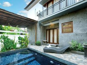 a swimming pool in front of a house at Villa Ariani Keselurahan, 3 BR in Keramas
