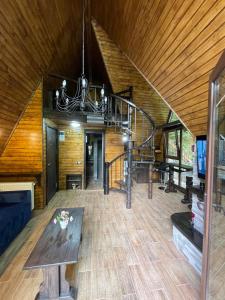 a living room with a wooden ceiling and a spiral staircase at Cabana Zimbru Transfagarasan in Arefu