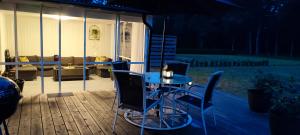 una mesa y sillas en una terraza por la noche en Boende i Målaskog, en Ryssby