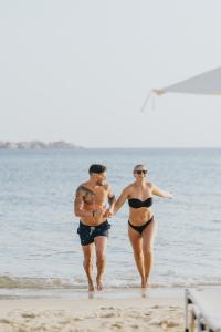 um homem e uma mulher andando na praia em Aegean Palace em Plaka