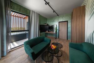 a living room with two green chairs and a table at Hotel Palms Beach Kiten in Kiten