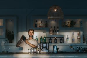 um homem parado atrás de um balcão num bar em Aegean Palace em Plaka