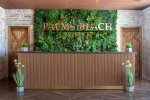 a restaurant with a green wall with a sign that reads palms beach kitchen at Hotel Palms Beach Kiten in Kiten +167 photos