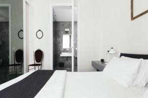 アヴォラにあるShurhuq Ospitalità Sicilianaのベッドルーム1室(白いベッド1台、椅子2脚付)