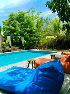 una piscina con 2 colchones y mesas al lado en Richards Cabanas en Tissamaharama