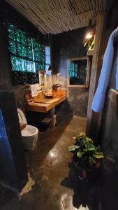 a bathroom with a sink and a toilet and a table at Mount Kilimanjaro 360 view Cottage in Uru