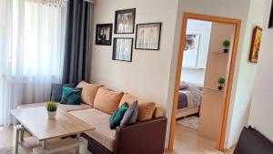 a living room with a couch and a table at Apartament Orange Piastowska in Ostróda