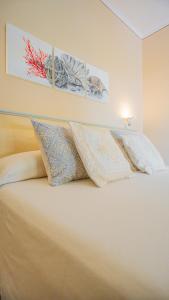 a bedroom with a bed with two pillows on it at Hotel Lu Pitrali in San Teodoro