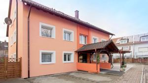 ein orangefarbenes Gebäude mit einem Pavillon davor in der Unterkunft Hotel Victoria in Weil am Rhein