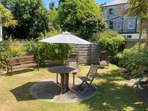 stół z parasolem, 2 krzesłami i ławką w obiekcie Cavendish Central Bournemouth w Bournemouth