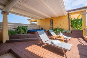 two chairs and a table on a wooden deck at Hotel Lu Pitrali in San Teodoro