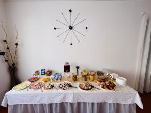 una mesa con muchas donas y un reloj en la pared en VILLA DEI FIORI, en Bellaria-Igea Marina