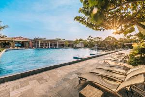 uma piscina num resort com espreguiçadeiras em The Victoria Resort Sam Son em Sam Son