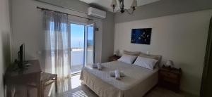 1 dormitorio con cama y ventana grande en Pelagia Beach Studios, en Agia Pelagia - Citera
