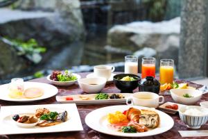 einen Tisch mit Teller mit Lebensmitteln und Gläsern Orangensaft in der Unterkunft Imabari Kokusai Hotel in Imabari