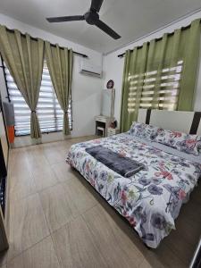 1 dormitorio con 1 cama con colcha de flores en Kampungstay by The LiliZ en Pekan