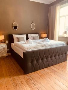 un grande letto in una camera da letto con due specchi sul muro di The Hampton Hock's - Wellness & Wine a Freinsheim Altre 116 foto