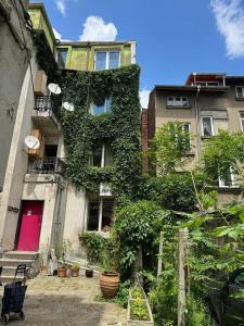 a building with ivy growing on the side of it at 8 bedrooms house with city view enclosed garden and wifi at Sofia 6 km away from the slopes in Sofia