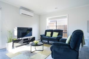 Wyndham ValeにあるHome away from homeのリビングルーム(青い椅子2脚、テレビ付)