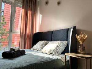 un letto con una coperta blu e una finestra di Hill Namai a Palanga