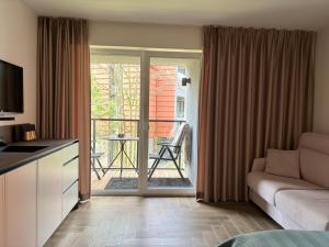 un soggiorno con un divano e una porta scorrevole in vetro di Hill Namai a Palanga