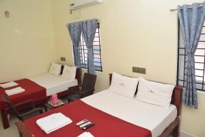 Zimmer mit 2 Betten, einem Tisch und Stühlen in der Unterkunft TS-K-MARVELL in Rāmeswaram