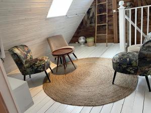 Habitación con sillas, mesa y alfombra. en Galleriet BnB en Stenkyrka