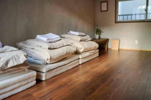 four stacks of blankets sitting on top of a wooden floor at Miki in Osaka