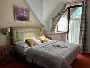 una camera da letto con un letto con cuscini gialli e una finestra di Wellness Pension 7 a Harrachov