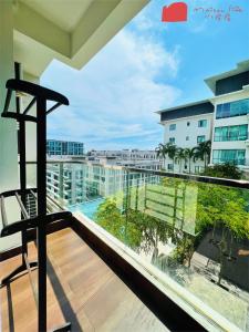 a balcony with a chair and a view of a building at Maison life 小居屋 The Loft Imago in Kota Kinabalu