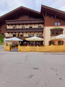 ein großes Gebäude mit Sonnenschirmen davor in der Unterkunft Hotel Restaurant Liesele Sonne in Sankt Leonhard im Pitztal