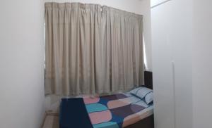 ein kleines Schlafzimmer mit einem Bett und einem Fenster in der Unterkunft Santai Homestay in Kota Kinabalu