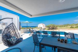 eine Terrasse mit Tisch und Stühlen und dem Meer in der Unterkunft Sunset mood modern ap with a pool for 6 in Novalja