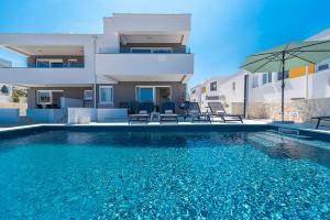ein Swimmingpool vor einem Haus in der Unterkunft Sunset mood modern ap with a pool for 6 in Novalja