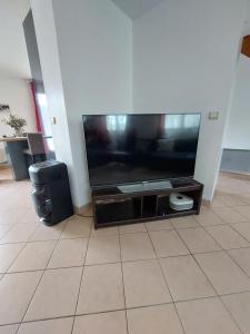 a flat screen tv sitting on a entertainment center at Maison de ville in Dourdan +4 photos