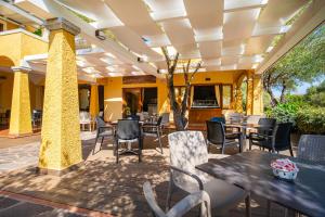 un patio in un ristorante con tavoli e sedie di Hotel Lu Pitrali a San Teodoro
