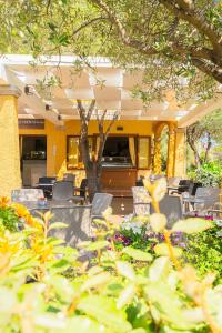 a patio with chairs and a table and flowers at Hotel Lu Pitrali in San Teodoro