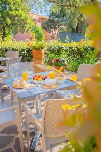 a table with plates of food and drinks on it at Hotel Lu Pitrali in San Teodoro