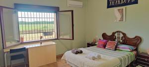 a small bedroom with a bed with a window at Casa Rural Finca San Bernardo 3 estrellas in Montehermoso