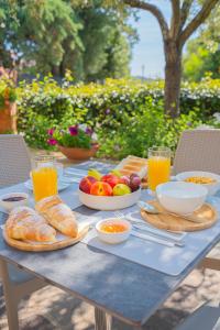 a table with plates of food and drinks on it at Hotel Lu Pitrali in San Teodoro