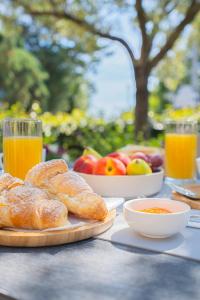 a table topped with plates of bread and bowls of fruit at Hotel Lu Pitrali in San Teodoro