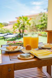 a table with plates of food and glasses of orange juice at Hotel Lu Pitrali in San Teodoro