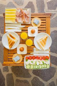 a wooden table with plates of food on it at Hotel Lu Pitrali in San Teodoro