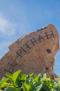 een steen met het woord tuin erop geschreven bij Hotel Lu Pitrali in San Teodoro
