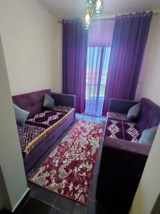 a living room with a purple couch and a rug at Porto matrouh in Marsa Matruh +2 photos