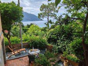 a patio with a table and a bench and water at B&B La taverna di Mulinetti in Recco